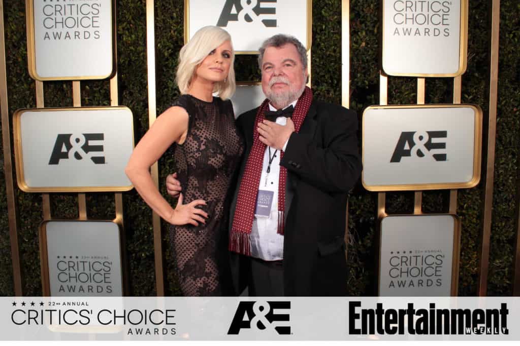 Guests posing against an event backdrop
